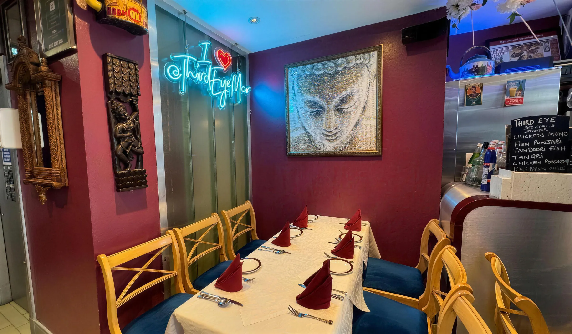 The dining room with its neon and Buddha mural